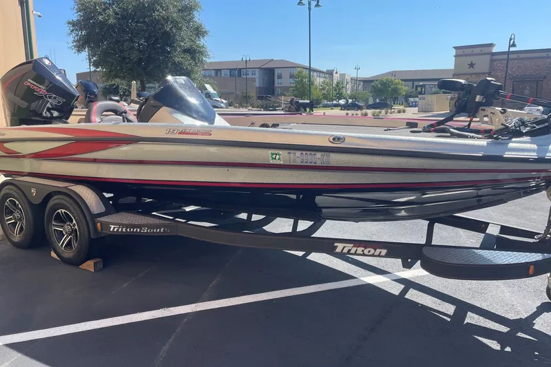 The Image of 2022 Triton 19 TrX Patriot boat on trailer, parked outdoors in sunny setting. - 0