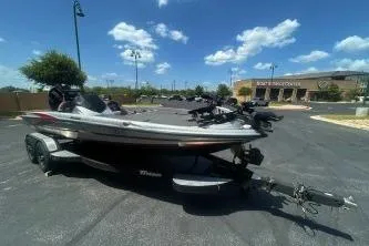 Slide: The Image of 2022 Triton 19 TrX Patriot boat on trailer in sunny parking lot. - 2