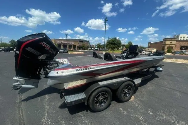 Slide: The Image of 2022 Triton 19 TrX Patriot boat on trailer in parking lot, sunny day. - 2