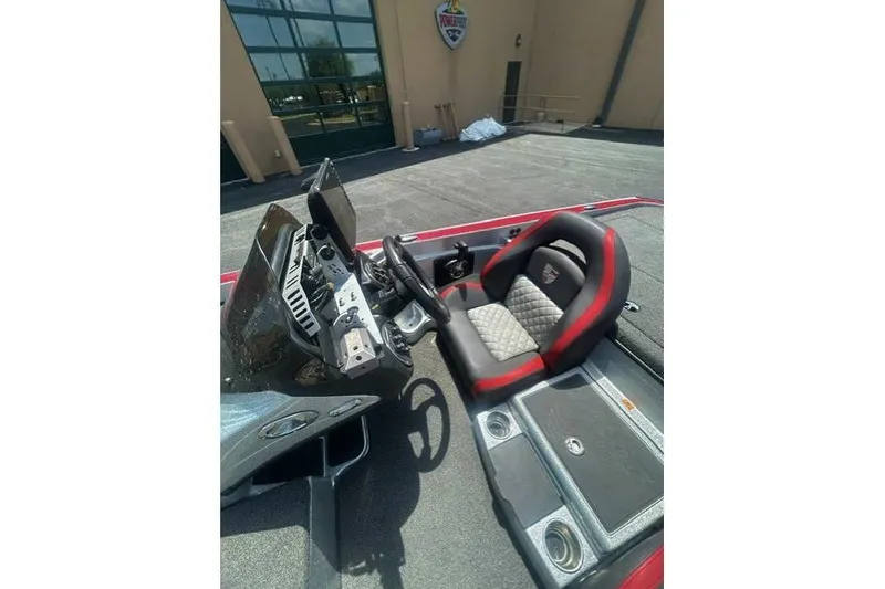 Slide: The Image of 2022 Triton 19 TrX Patriot boat interior with steering wheel and cushioned seat. - 11