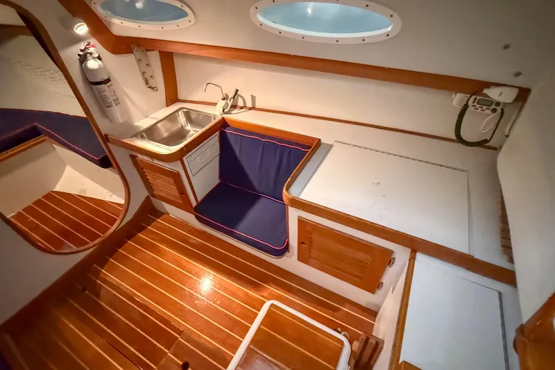 Slide: The Image of Interior of 1997 Alerion Express 28 sailboat with wooden flooring and compact kitchenette. - 19