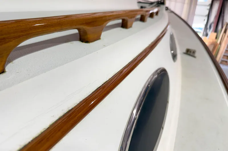 Slide: The Image of Close-up of 1997 Alerion Express 28 sailboat's polished wooden handrail and portholes. - 9