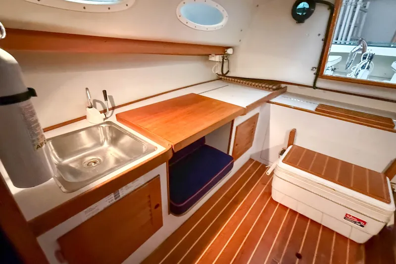 Slide: The Image of Interior of 1997 Alerion Express 28 sailboat with sink, wooden cabinetry, and cooler. - 23