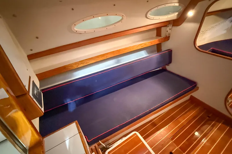 Slide: The Image of Interior of 1997 Alerion Express 28 sailboat with wooden accents and blue seating. - 17