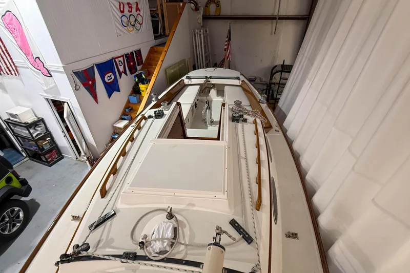 Slide: The Image of Alerion Express 28 sailboat from 1997 stored indoors, surrounded by nautical flags. - 10