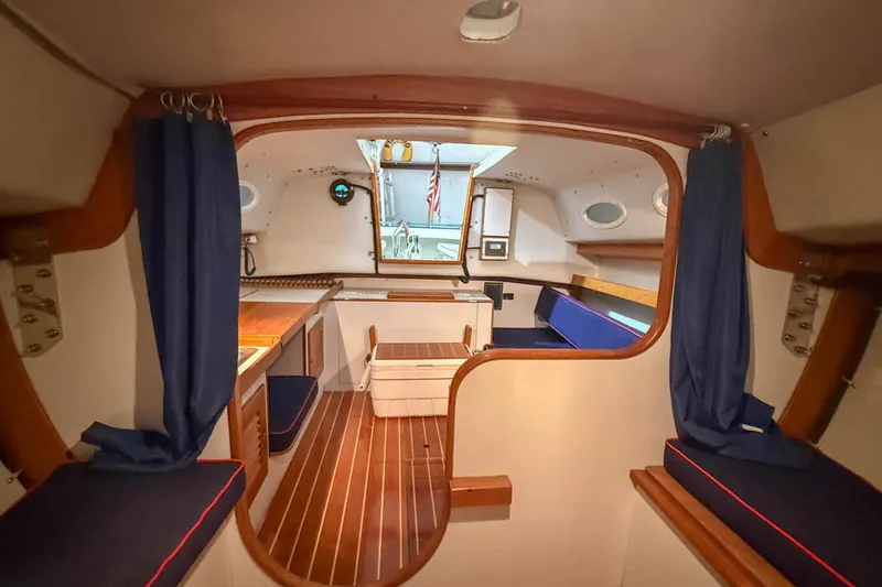 Slide: The Image of Interior of a 1997 Alerion Express 28 sailboat with wooden accents and blue seating. - 21
