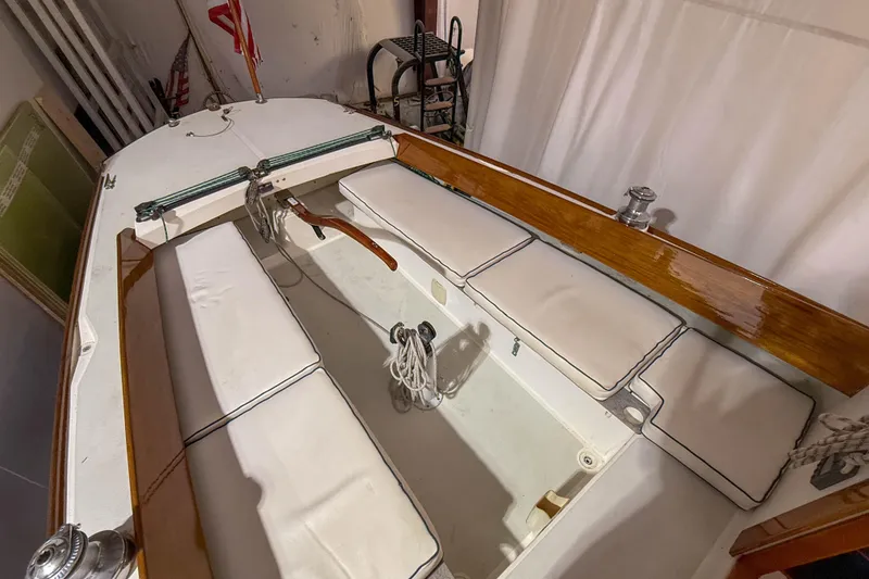 Slide: The Image of 1997 Alerion Express 28 sailboat interior with white cushions and polished wood trim. - 13