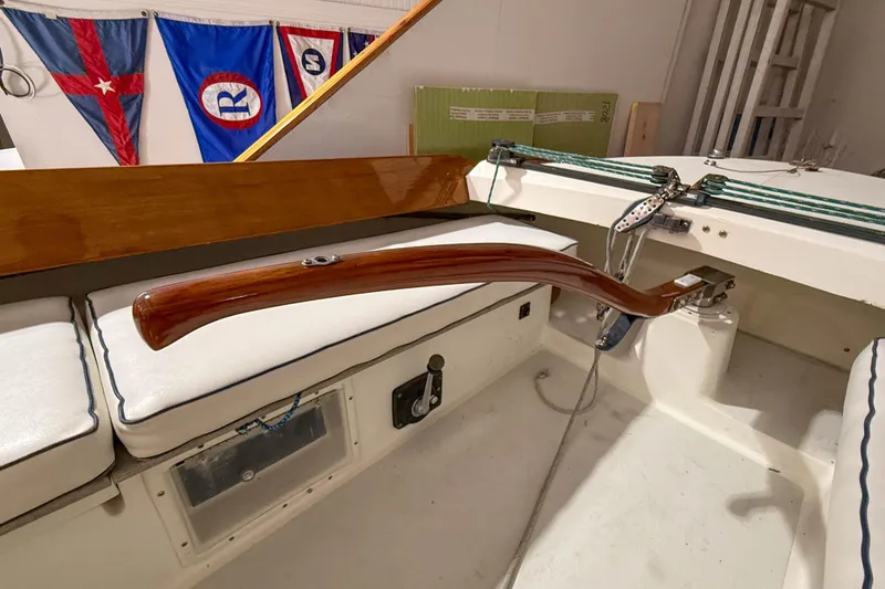 Slide: The Image of Interior of a 1997 Alerion Express 28 sailboat with wooden tiller and nautical flags. - 14