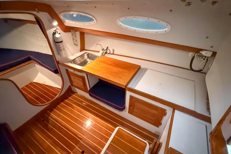 Slide: The Image of Interior of 1997 Alerion Express 28 sailboat with wooden flooring and compact kitchenette. - 18