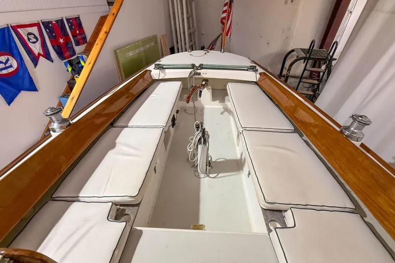 Slide: The Image of 1997 Alerion Express 28 sailboat interior with white cushions and polished wood trim. - 11