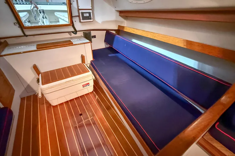 Slide: The Image of Interior of 1997 Alerion Express 28 sailboat with blue seating and wooden flooring. - 22