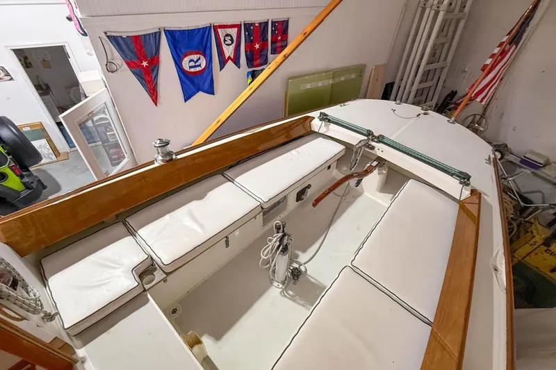 Slide: The Image of 1997 Alerion Express 28 sailboat interior with white seating and nautical flags displayed. - 12