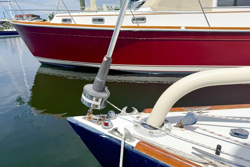 Slide: The Image of Bow of a 1997 Alerion Express 28 sailboat docked near a red boat. - 5