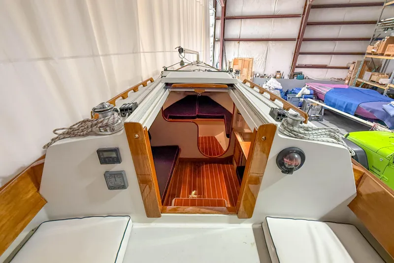 Slide: The Image of Interior view of a 1997 Alerion Express 28 sailboat, showcasing cabin entrance and seating. - 15