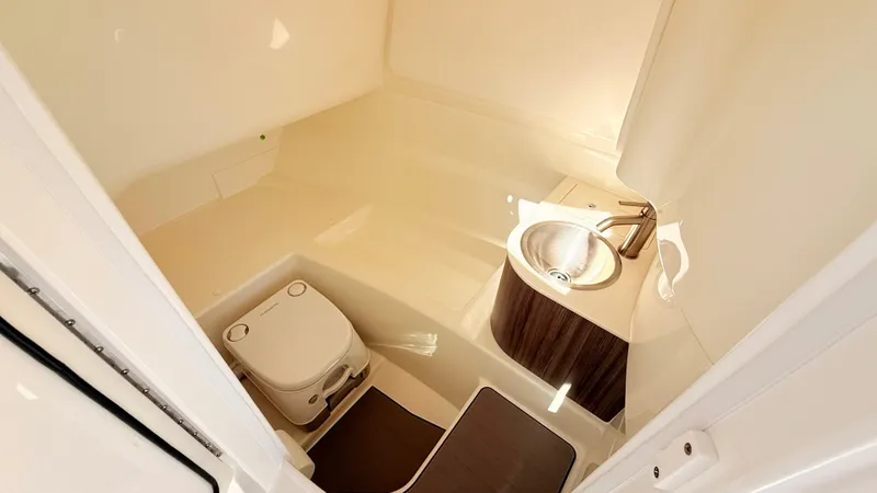 Slide: The Image of Interior view of a boat cabin with a toilet and sink, designed in light colors. - 42