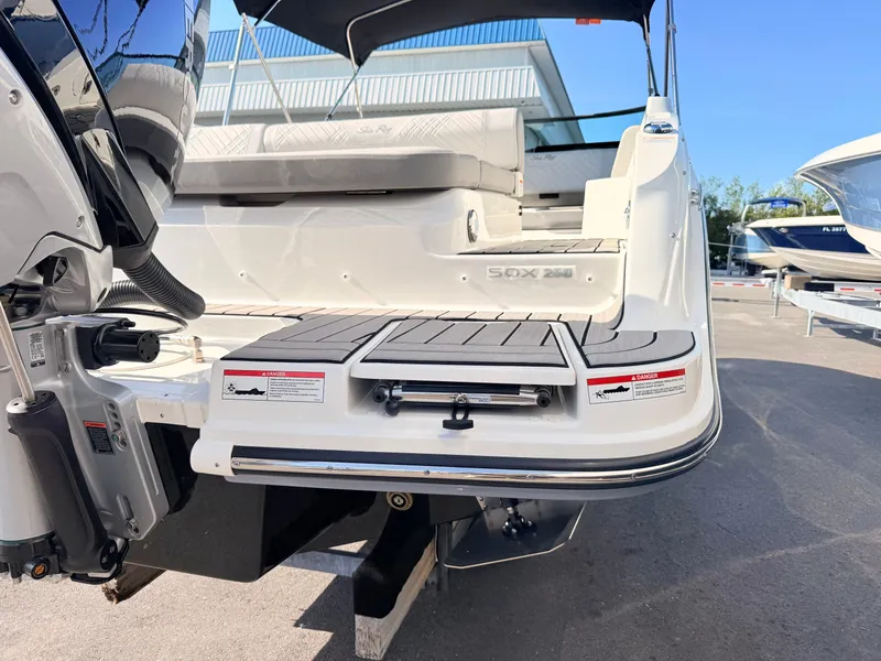 Slide: The Image of The image shows the stern of a 2026 Sea Ray SDX 250 Outboard boat with a swim platform. - 9