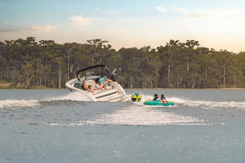 Slide: The Image of A 2025 Sea Ray SDX 270 Surf towing an inflatable tube on a calm lake. - 20