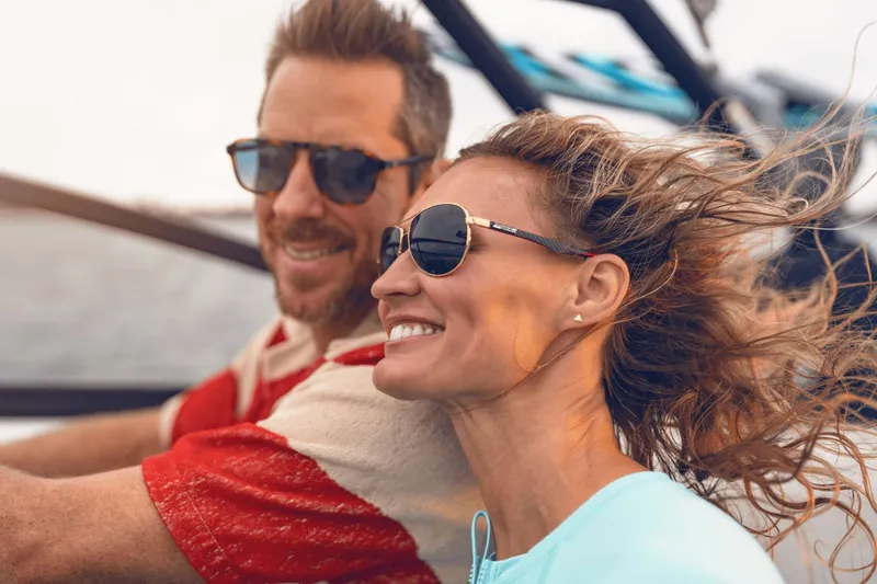 Slide: The Image of A couple enjoying a boat ride, smiling and wearing sunglasses. - 11