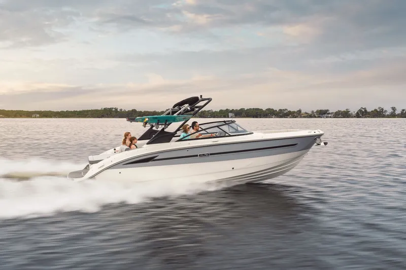 Slide: The Image of A 2025 Sea Ray SDX 270 Surf speeds across the water, with several people on board. - 1
