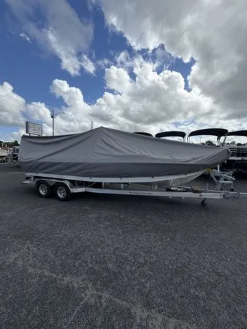 Slide: The Image of A 2025 Ranger 2360 Bay boat covered on a trailer under a cloudy sky. - 27