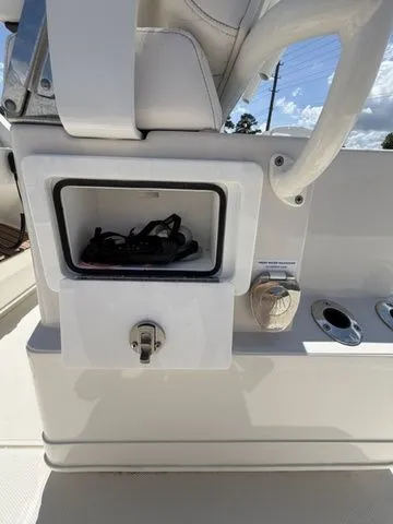 Slide: The Image of A 2025 Ranger 2360 Bay boat with an open storage compartment and cup holders. - 20