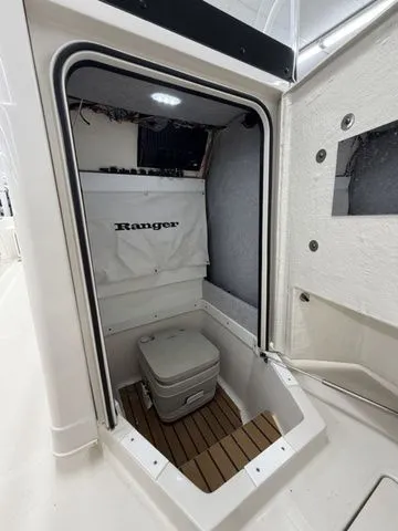 Slide: The Image of Interior of a Ranger 2360 Bay boat featuring a toilet and wooden flooring. - 14