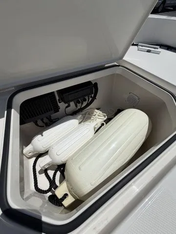 Slide: The Image of An open storage compartment on a boat reveals several white fenders and ropes. - 10