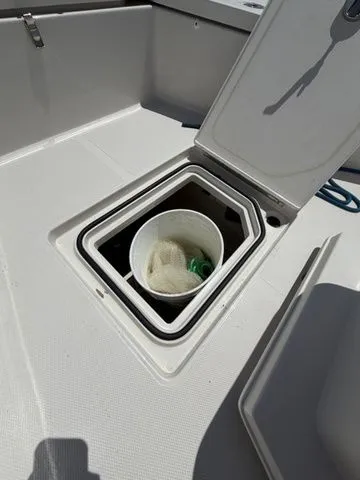 Slide: The Image of An open storage compartment on a boat with a bucket and net inside. - 17