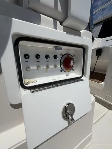 Slide: The Image of Close-up of a control panel on a boat with several switches and a large red button. - 23