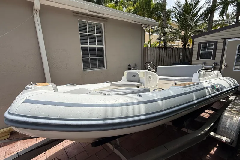 Slide: The Image of 2022 AB Inflatables ABJET 430XP boat on trailer, parked beside a house. - 4