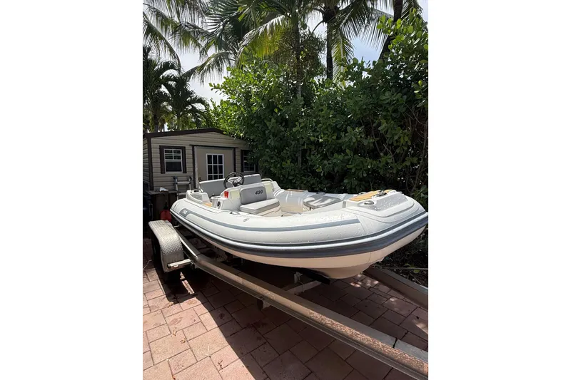 Slide: The Image of 2022 AB Inflatables ABJET 430XP boat on trailer, surrounded by lush greenery. - 14
