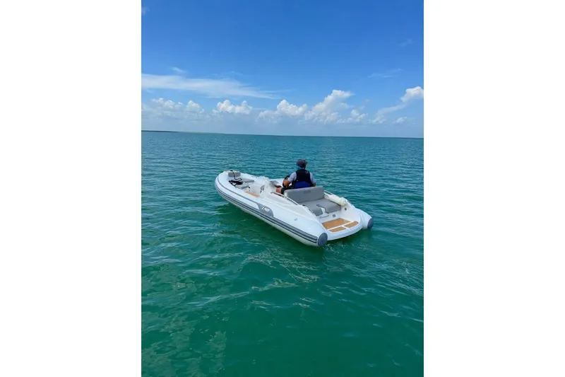 Slide: The Image of 2022 AB Inflatables ABJET 430XP on calm ocean waters under a clear blue sky. - 1
