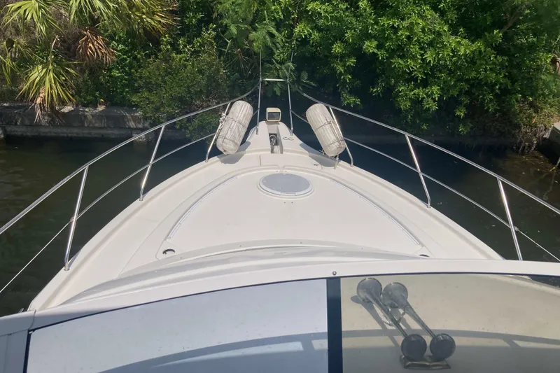 Slide: The Image of 2002 Silverton 39 Motor Yacht bow view, docked near lush greenery. - 4
