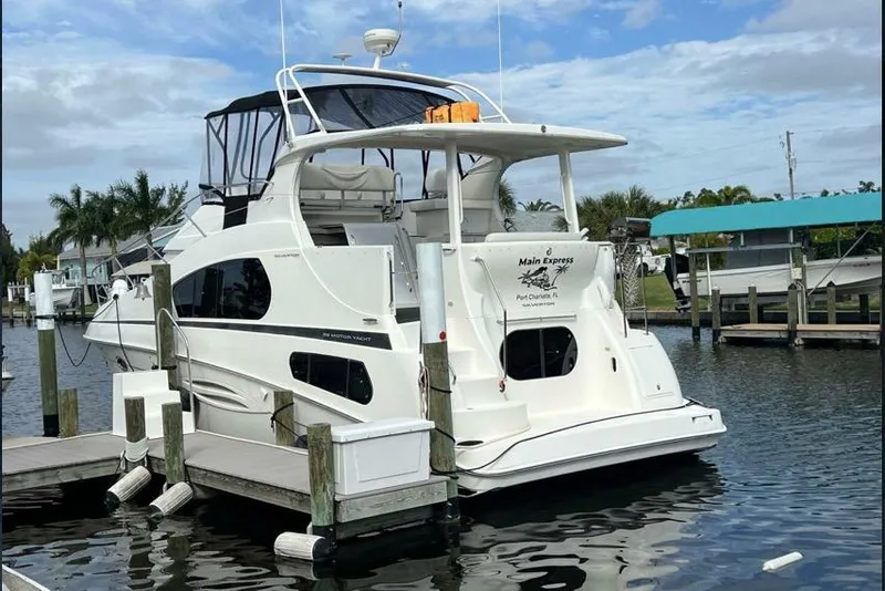 Slide: The Image of 2002 Silverton 39 Motor Yacht docked in a marina, featuring sleek design and spacious deck. - 3
