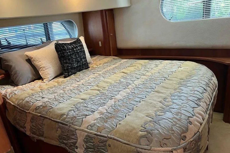 Slide: The Image of Luxurious bedroom interior of 2002 Silverton 39 Motor Yacht with elegant bedding and window view. - 19