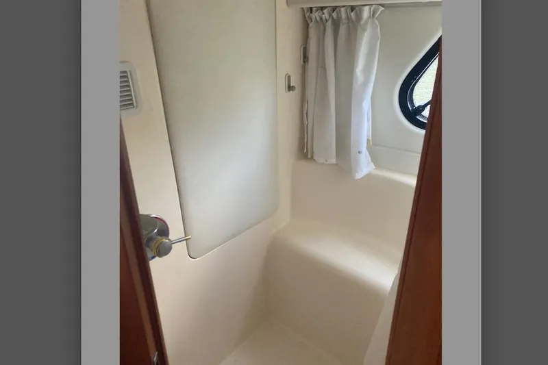 Slide: The Image of 2002 Silverton 39 Motor Yacht bathroom interior with window and curtain. - 22