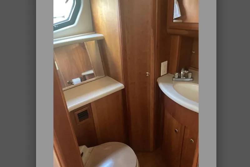 Slide: The Image of Bathroom interior of 2002 Silverton 39 Motor Yacht with wooden cabinetry and sink. - 21