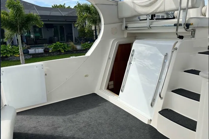 Slide: The Image of 2002 Silverton 39 Motor Yacht interior with stairs and open hatch, surrounded by lush greenery. - 12