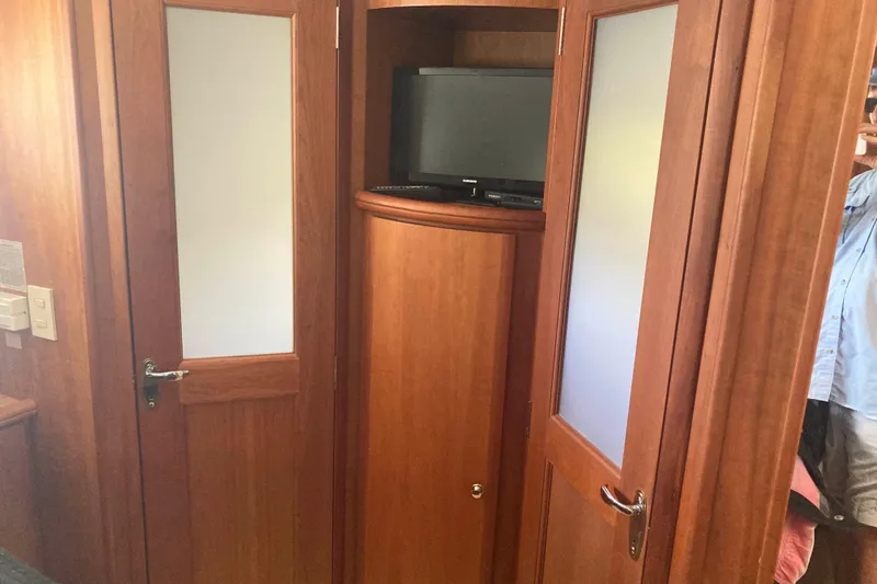 Slide: The Image of Interior of 2002 Silverton 39 Motor Yacht with wooden doors and a small TV. - 20