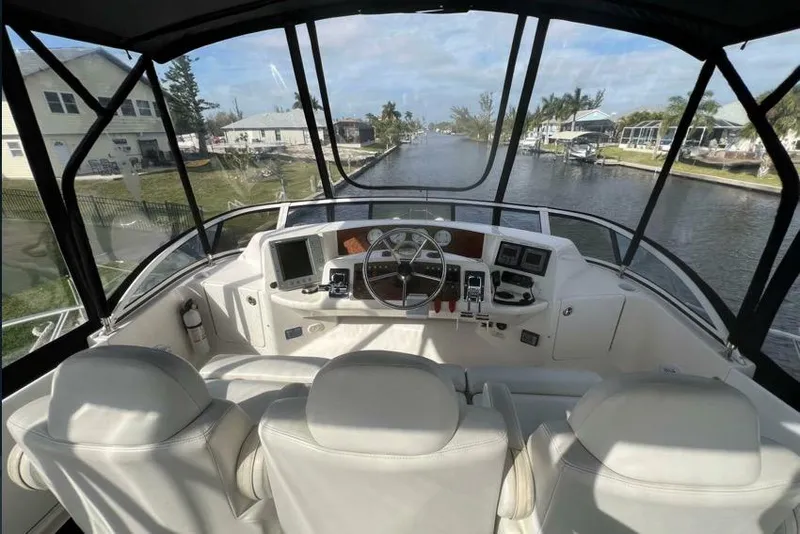 Slide: The Image of 2002 Silverton 39 Motor Yacht helm with canal view, featuring modern navigation equipment. - 5
