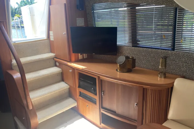 Slide: The Image of Interior of 2002 Silverton 39 Motor Yacht with stairs, TV, and wooden cabinetry. - 13