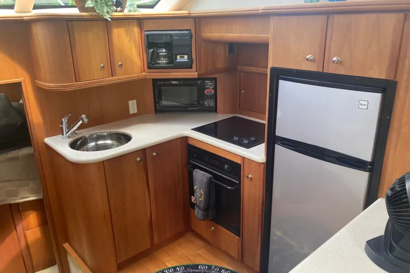 Slide: The Image of 2002 Silverton 39 Motor Yacht kitchen with sink, microwave, stove, and refrigerator. - 18
