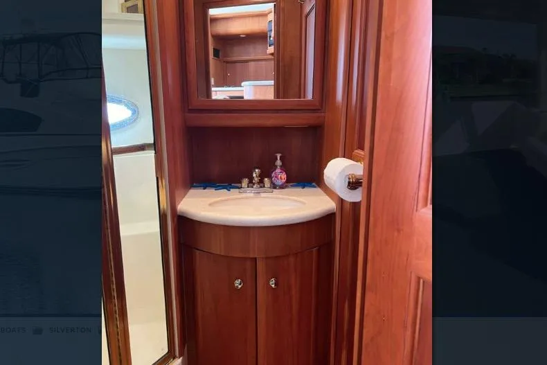 Slide: The Image of 2002 Silverton 39 Motor Yacht bathroom with wooden cabinetry and sink. - 24