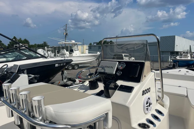 Slide: The Image of 2026 Bulls Bay 2000 boat with Garmin navigation, docked under a partly cloudy sky. - 5