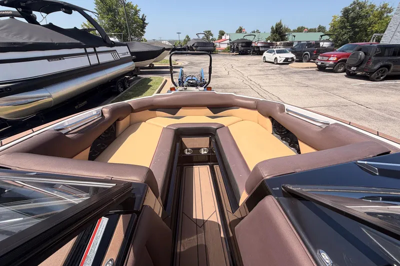 Slide: The Image of 2019 Moomba Makai boat interior with tan and brown seating in a parking lot. - 10