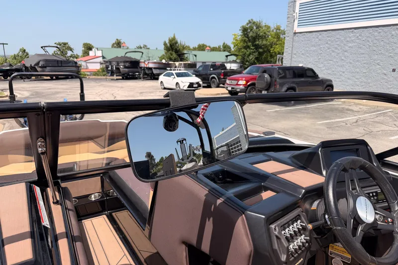 Slide: The Image of 2019 Moomba Makai boat interior with steering wheel and rearview mirror in a parking lot. - 34