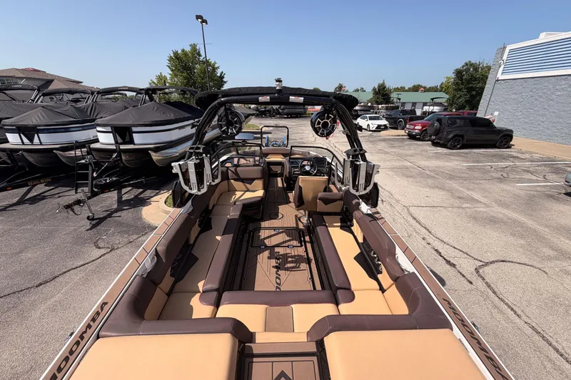 Slide: The Image of 2019 Moomba Makai boat with spacious seating, parked in a dealership lot. - 24