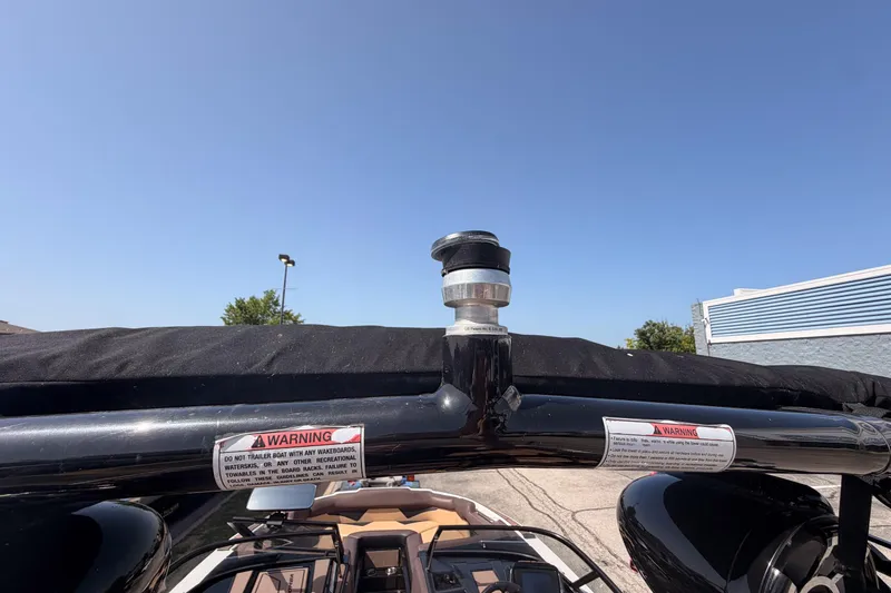 Slide: The Image of 2019 Moomba Makai boat tower with warning labels under clear blue sky. - 9