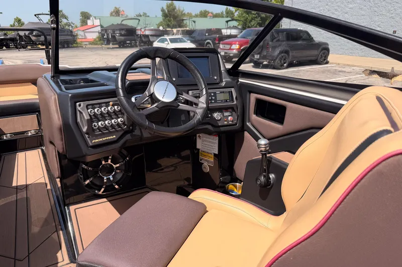 Slide: The Image of 2019 Moomba Makai boat interior with steering wheel, control panel, and tan seating. - 32