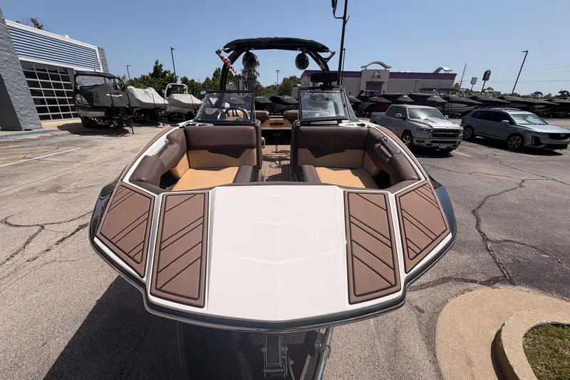 Slide: The Image of 2019 Moomba Makai boat with brown seating, parked outdoors in a dealership lot. - 2